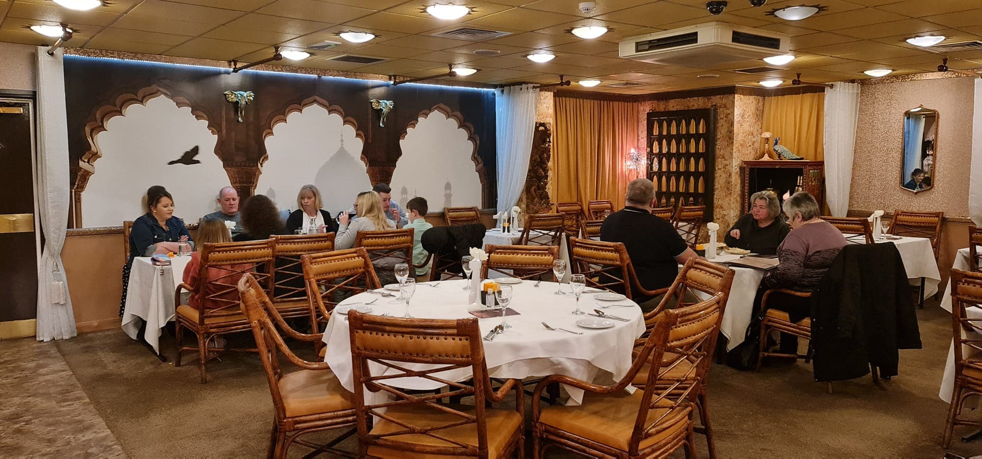 Guests dining beneath the Mughal arch mural