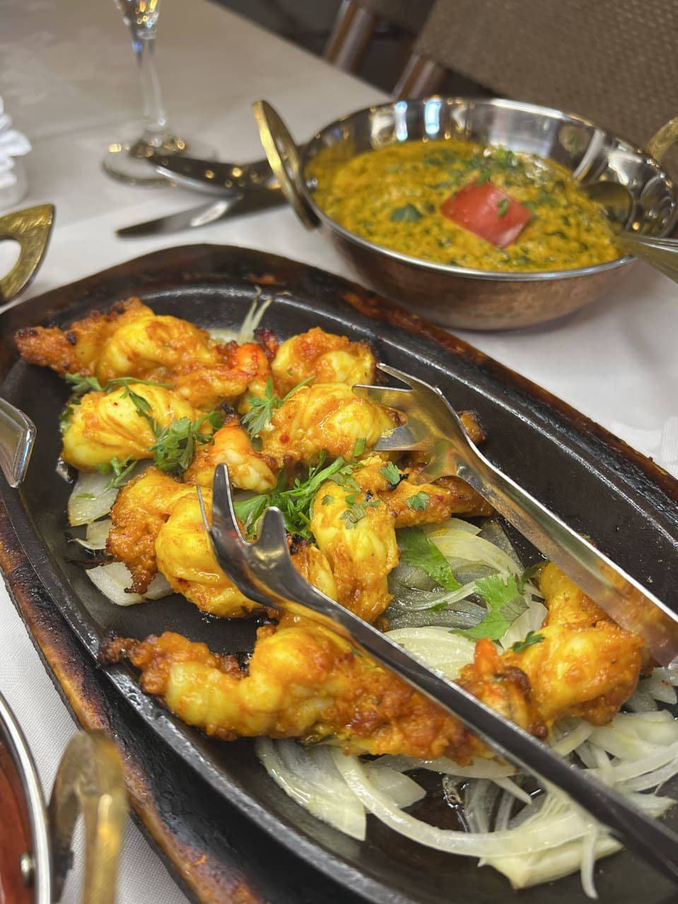 Sizzling prawns on a hot plate with dal